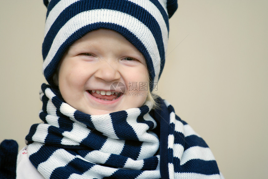 穿着冬帽和围巾的微笑小女孩图片