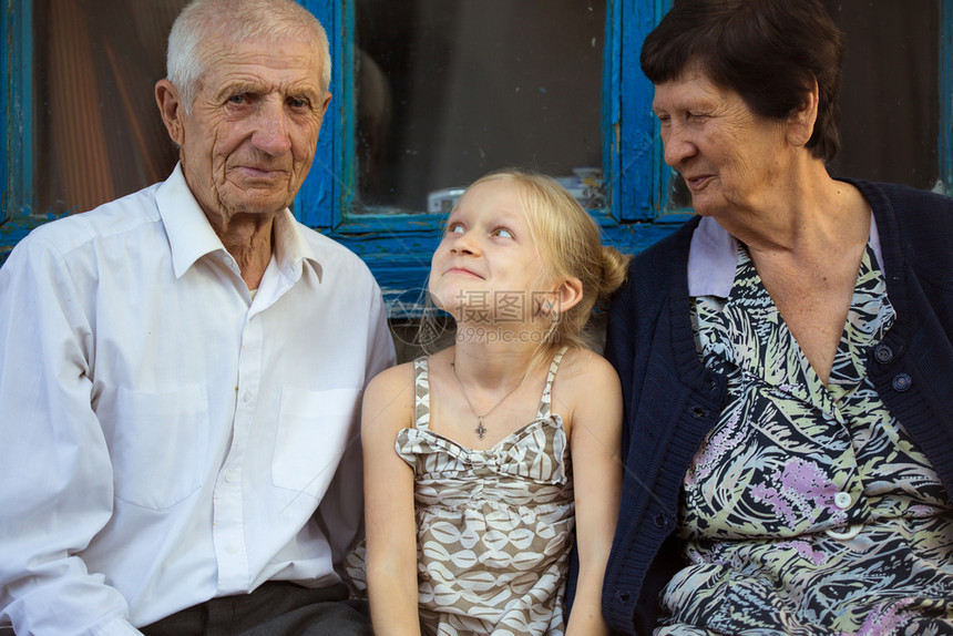 孙女带着子拥抱父母坐在农村家庭门口图片