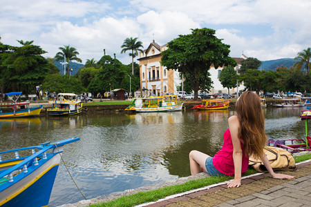 巴西里约女孩看着一个抛尸湾的女孩坐在码头上背景
