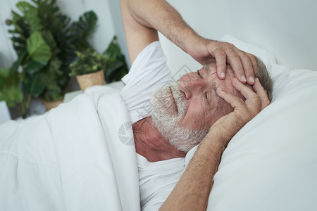 老年男子独睡头痛在房间里床上做恶梦或背景图片
