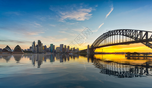 悉尼市中心包括岩石桥和歌剧院以及人为的海洋反射戏剧全景的日落光闪烁港人造反射背景