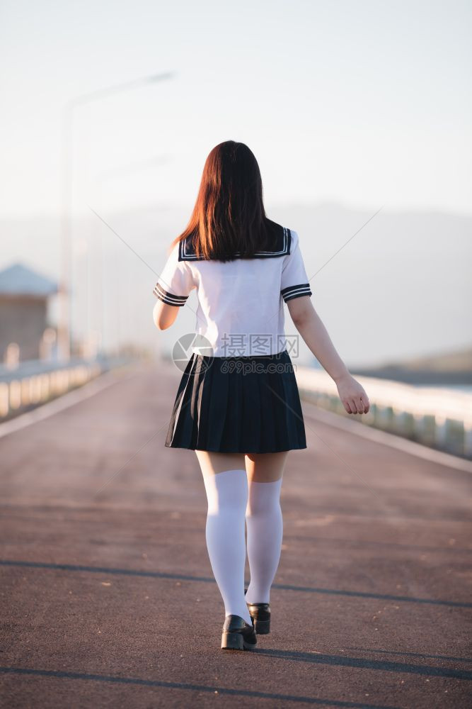 带着步行道和河边微笑的日本女学生制服图片