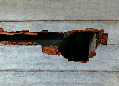 附有污垢木墙被大洞白蚁损坏的木材墙房屋结构有严重的白蚁问题毁坏的旧木墙背景