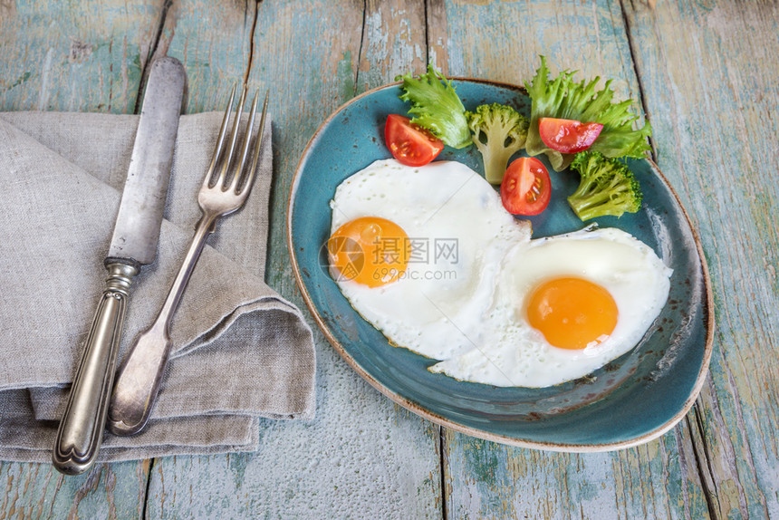 早餐由炒鸡蛋和蔬菜组成在旧木制餐桌上生菜式图片