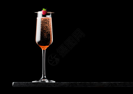 粉红玫瑰香槟的优雅杯子黑大理石板上的红莓黑色底的大理石板上图片