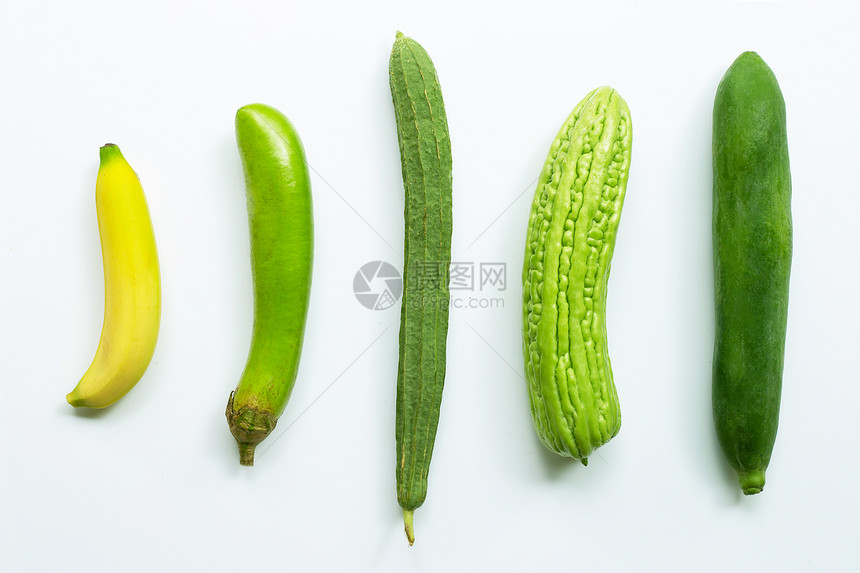 香蕉、绿色长茄子乳酪苦瓜白底绿木。图片