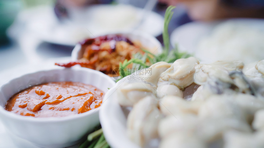 年轻女在餐厅吃牡蛎海鲜少女快乐地吃食物图片