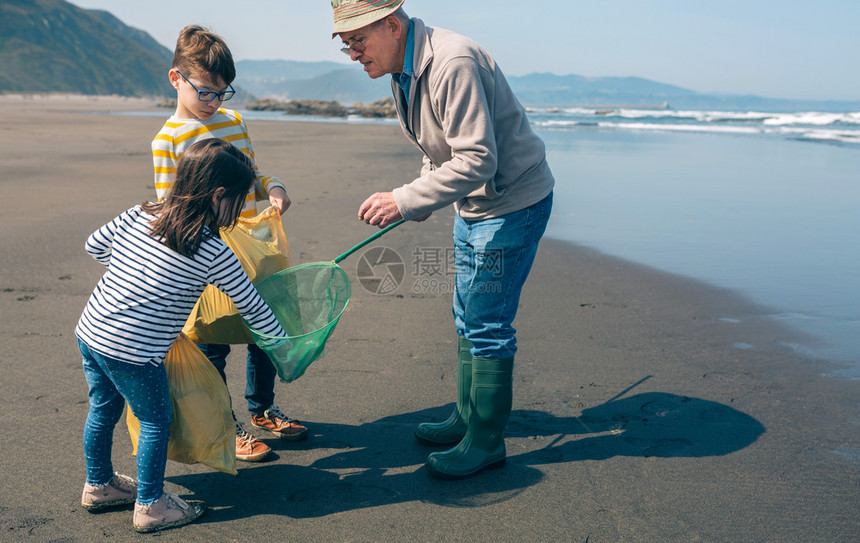 志愿者用渔网把垃圾从海中带走图片