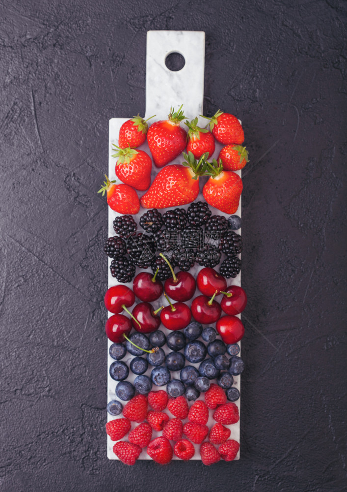 白色大理石板上的新鲜有机夏季果子酱深色厨房桌底背景草莓蓝黑和樱桃图片
