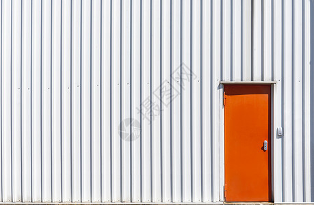 工业建筑外墙有金属橙色门和白铝板墙色仓库有金属墙和橙色门图片