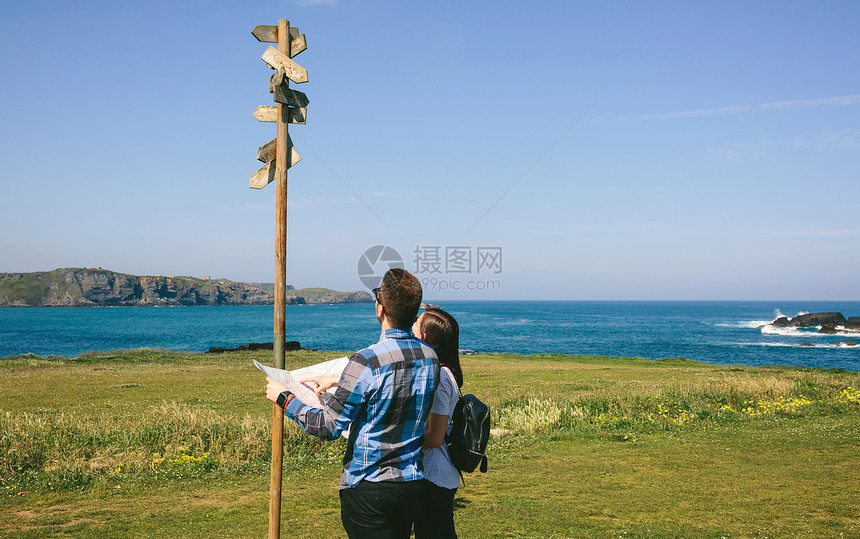 一对年轻夫妇在海岸附近寻找和方向标志一对夫妇在寻找和方向标志图片