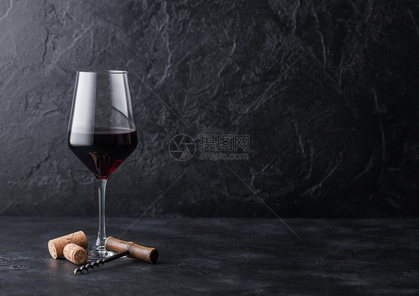 一杯优雅的红葡萄酒配有软木瓶和黑石底的软木瓶图片