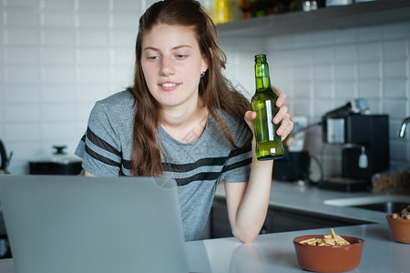 边喝啤酒边看剧的女孩图片