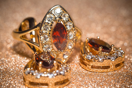 金色的钻石玫瑰金色时装环深红的石长袍仿制品背景