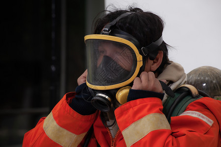 身戴面具的消防员和安全套用于白背景消防灭火安全概念图片