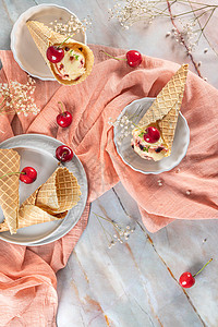 大理石表面有冰淇淋和樱桃水果的传统华夫饼锥图片
