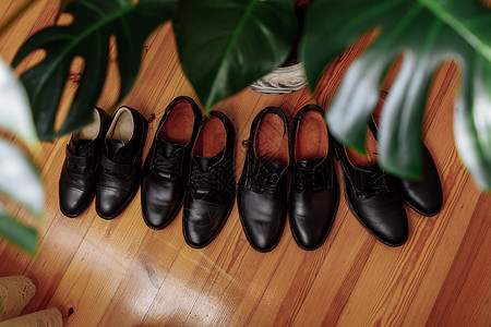 男皮鞋子概念黑皮鞋放在种植厂附近的地板上男皮鞋概念四双男皮鞋靴子背景图片