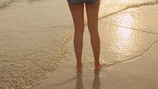 年轻快乐的女子在比基尼放松快乐地走在热带海边当日落时假期暑的概念图片