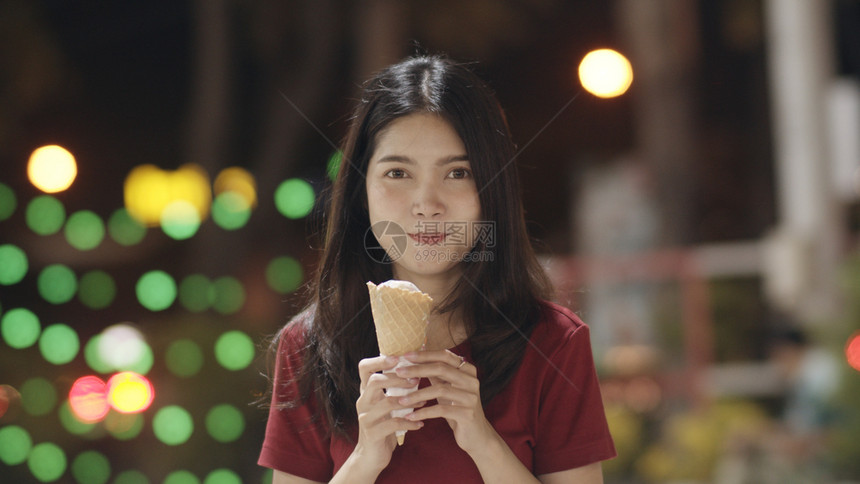 年轻女在泰国的bangko旅行美丽的女在khaosn路上走来去感到快乐和吃冰淇淋图片