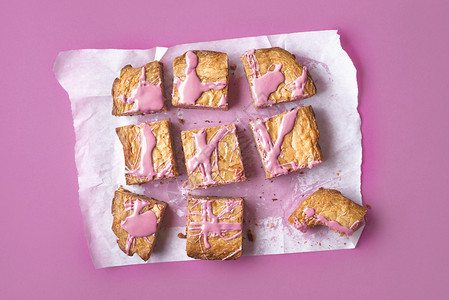 粉红巧克力布朗尼切成烘烤纸和粉红背景在切片红宝石巧克力蛋糕上方新的巧克力甜点平板自制高清图片素材
