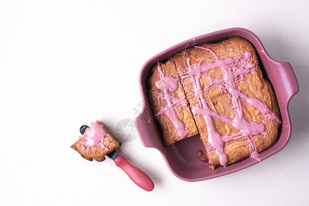 盘子里的粉红褐色蛋糕和白桌上的部分红宝石巧克力甜点上面的红宝石粉甜点平整的色甜点美味的粉红色巧克力食品甜的高清图片素材