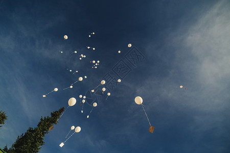 白气球飞向蓝天白云背景图片