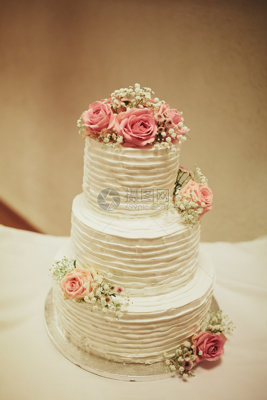 在活动空间婚礼蛋糕餐桌上的婚礼蛋糕美丽多彩的婚礼蛋糕的装饰在活动空间的盛装图像图片