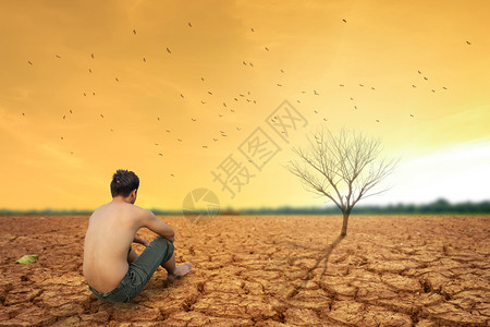人坐在地上靠近干燥的陆地和热干燥的空气图片