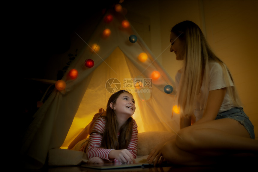 快乐的小女孩和母亲微笑在家里帐篷露营创造思维图片