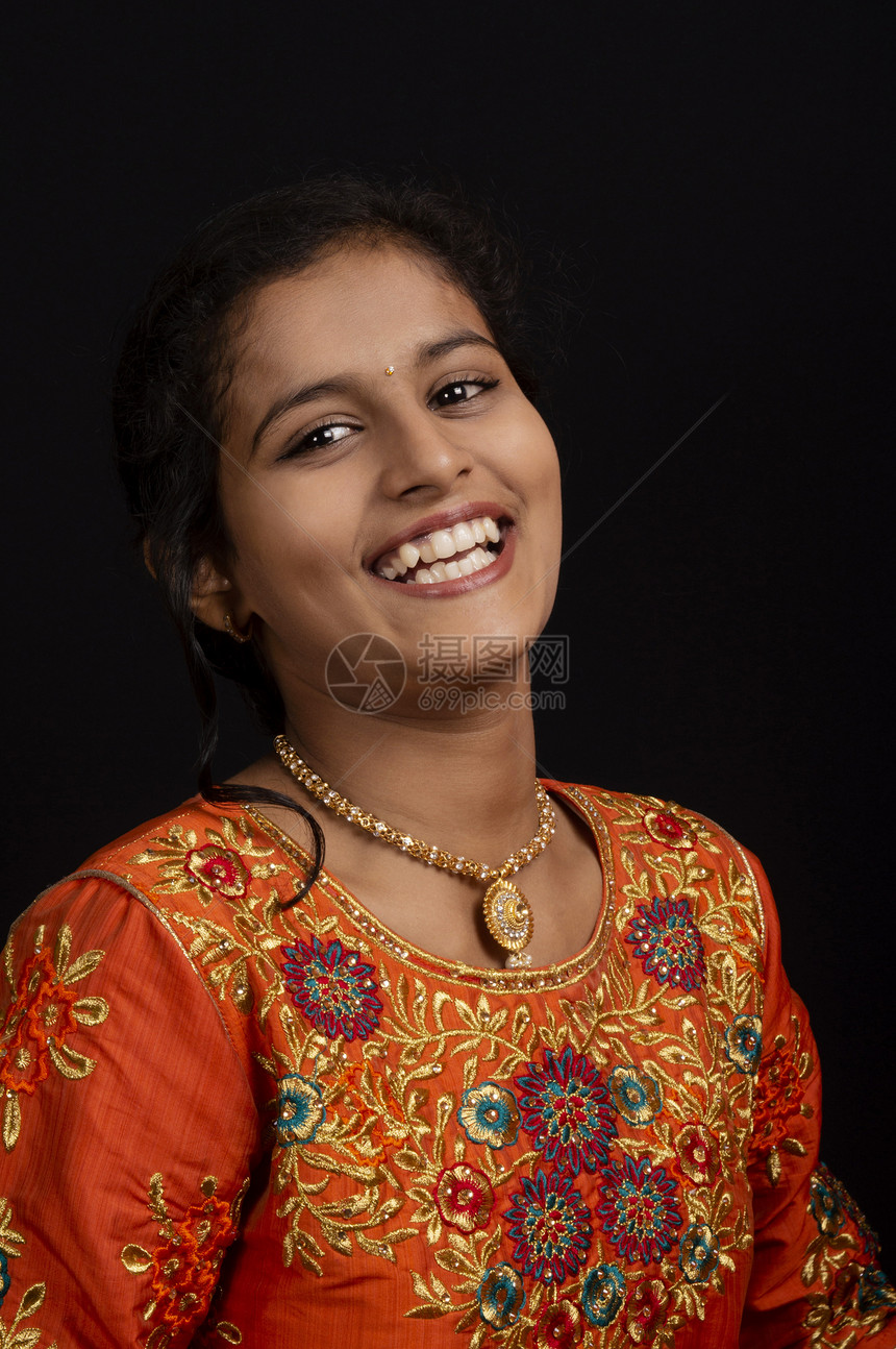 一个快乐的印度年轻女孩肖像在黑人背景下微笑图片