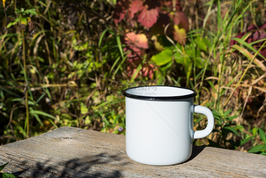 白色露营火用太阳光束和草叶制成的咖啡杯空子用来促销设计图片