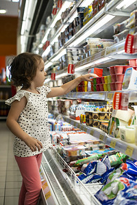 在超市购买酸奶的小女孩背景图片