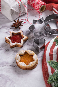 在大理石表面躺着有圣诞饼干的平板有圣诞装饰松树枝果酱礼品和饼干切机背景图片