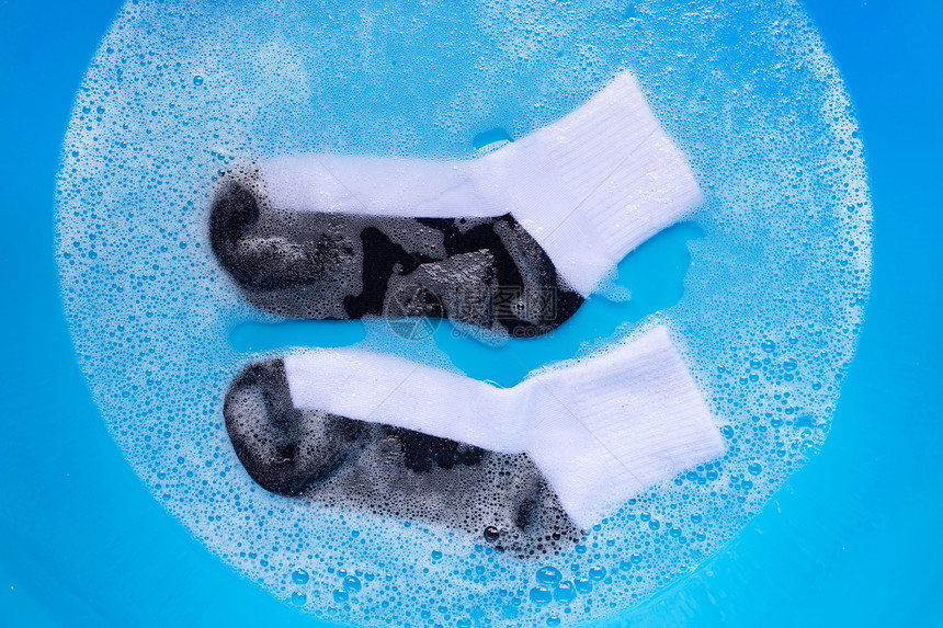 脏袜子浸泡在粉末洗涤水溶解中图片