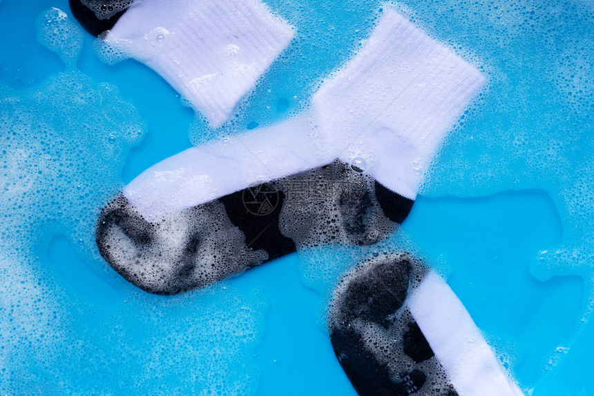 脏袜子浸泡在粉末洗涤水溶解中图片
