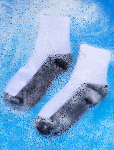 脏袜子浸泡在粉末洗涤水溶解中气泡高清图片素材