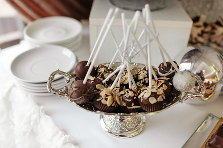 婚前糖果棒很多不同的甜点和巧克力餐桌上的银盘有坚果婚礼糖棒图片