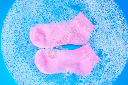 小猪猪采花贼粉色袜子浸泡在清洁水溶解中洗衣概念顶层视图背景