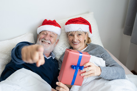 老年天主教人男女为早上的圣诞节日赠送礼物或退休的可爱夫妇生活方式概念图片