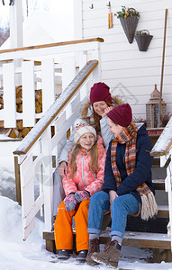 幸福的家庭在房子门廊上背景传统的挪威木屋图片