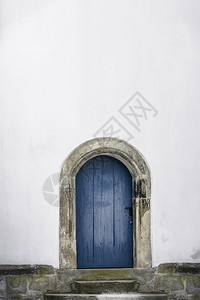 中世纪的拱门蓝色老木石头楼梯和白墙只有一扇门和白色的墙图片