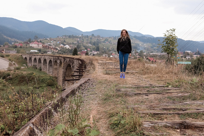 旅游少女在这条管道上走旧铁路在vorhta山村的老铁路道上走图片