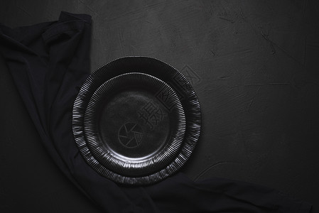 一张桌子上的空盘和黑厨房毛巾盘子上方的桌上的餐具桌布局图片