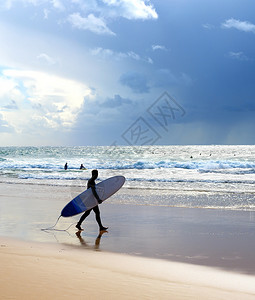 沙滩上有冲浪板的者海洋雨上吊脚印图片