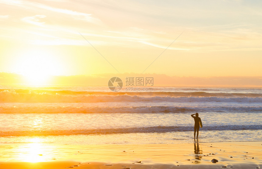 日落时在海边冲浪图片