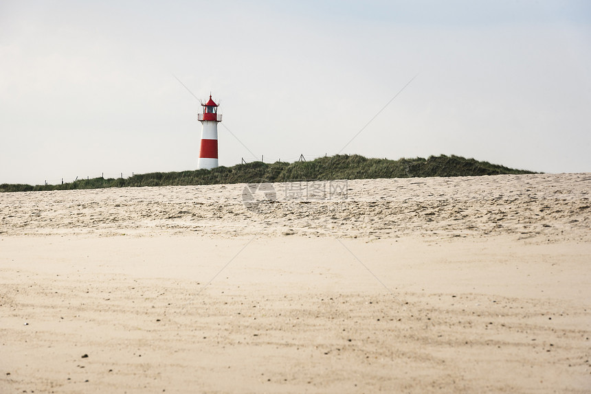 草丘和沙滩上的灯塔黄沙锡尔特岛北海德国阳光明媚的夏季海滩风景有灯塔和沙子图片