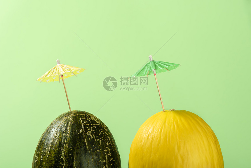 黄瓜和绿鸡尾酒伞阳光下绿色背景夏季饮料概念不同种类的甜瓜饮料成分图片