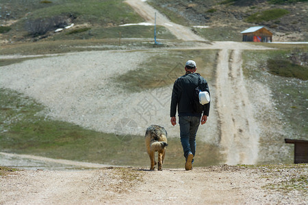 人与狗一起在山上行走图片