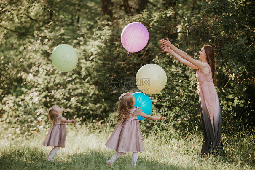 母亲和两个女儿在玩气球图片