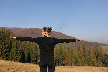 山顶上练瑜伽的少女背景图片